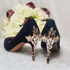 a pair of high heeled shoes with flowers in the back and on the side