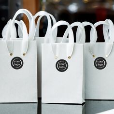 four white bags with black labels on them