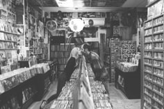 two men in a record store looking at records on the shelves and playing with them