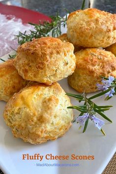 four biscuits on a white plate with rosemary sprigs and blue cheese scones