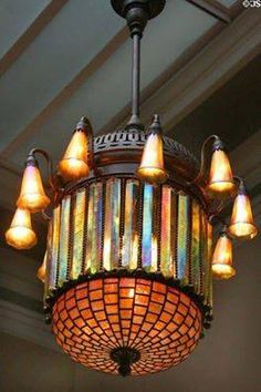 a chandelier hanging from the ceiling with many lights on it's sides