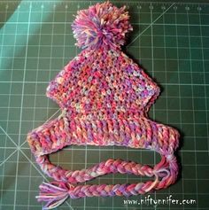 a knitted hat sitting on top of a cutting board