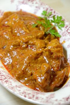 a close up of a plate of food with meat and gravy on it