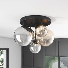 three clear globes are hanging from the ceiling in this modern style living room area