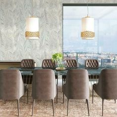 a dining room table with chairs and a vase on the table in front of a large window