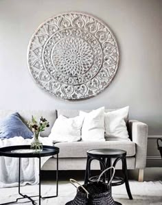 a living room filled with furniture and a large white circular wall art above the couch