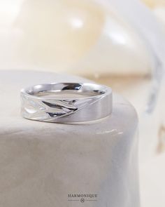 a silver ring sitting on top of a white table