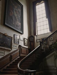 a staircase with pictures on the wall and paintings on the walls