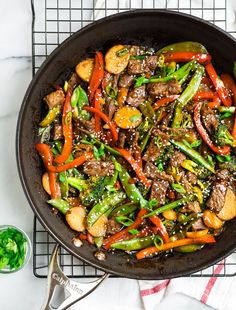 a skillet filled with stir fry vegetables and meat