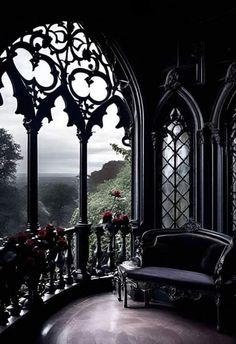 an ornate balcony with large arched windows and flowers on the table in front of it