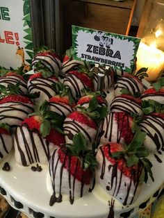 strawberries with chocolate drizzled on them are arranged on a platter