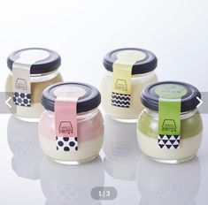 four jars with labels on them sitting next to each other