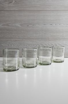 four glasses are lined up on a table