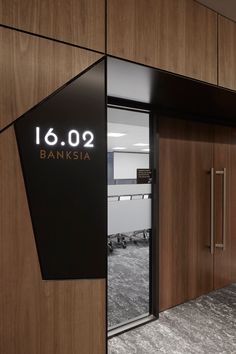 the entrance to an office building with glass doors and wooden paneling on the walls