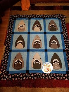 a quilted table topper with shark heads on it