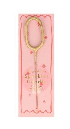 a gold colored scissors is on a pink card with red and white stars around it