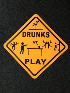 a yellow and black sign that says drunks at play