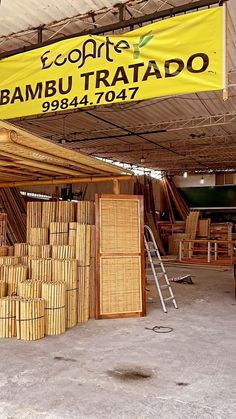 the inside of a bamboo shop with large stacks of wood in front of it and a banner hanging from the ceiling