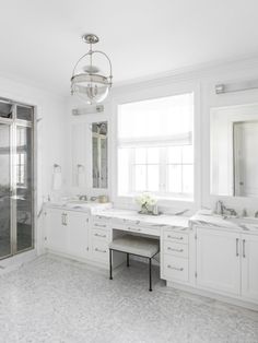 a large bathroom with two sinks and a shower stall in it's center area