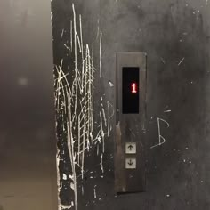 a black and white photo of a red light on a metal box with graffiti all over it