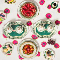 plates and bowls with fruit on them are arranged in the shape of flowered dishes