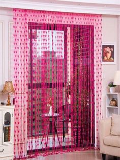 a living room filled with furniture and pink curtains