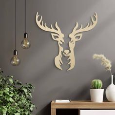 a deer head is mounted on the wall next to a potted plant and lamp