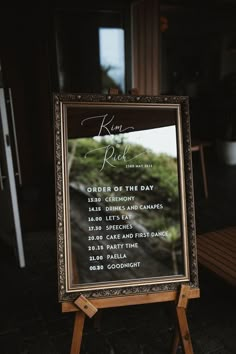 a sign that is sitting in front of a wooden table with a menu on it