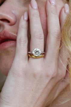 a close up of a person with a ring on their finger and her face to the side