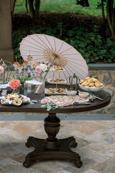 a table topped with lots of food and an umbrella