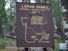 a sign showing the trail to lamar haines memorial wildlife area, located in the woods