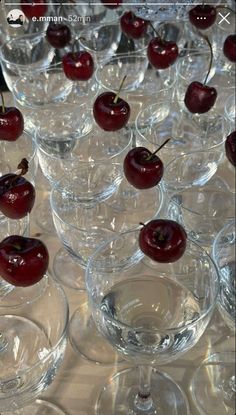 there are many wine glasses with cherries in them