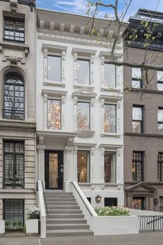 this is an image of a two story house in new york city with stairs leading up to the front door