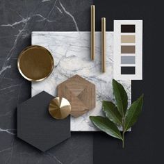 an assortment of items on top of a marble table with gold and black accessories next to it