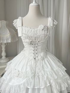 White jacquard fabric corset, under bust neckline and lace trim scallop edge hemline, lace-up closure front, decorated with white roses. Matching wih gothic or elegant classic lolita op and jsk.        	 		 			Size 			S 			M 			L 		 		 			Full Length 			75 			77 			79 		 		 			Bust 			75 			79 			83 		 		 			Waist 			61 			65 			69 		 		 			Shoulders 			34 			35 			36 White Gothic Dress, Goth Fits, Rose Details, White Goth, Lacey Dress, Light Blue Aesthetic, Classic Lolita, Fairy Dresses, Rosé Details