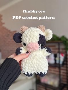 a hand holding a crocheted cow with the words chubby cow on it