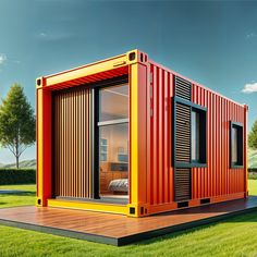 a red and yellow shipping container sitting on top of a wooden platform in the grass