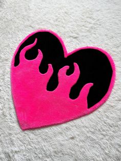 a pink and black heart shaped rug sitting on top of a white carpet