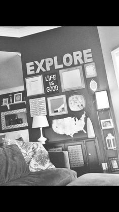 a black and white photo of a living room with pictures on the wall, bookshelves, and lamp