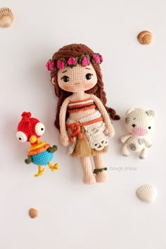 there is a crocheted doll next to two stuffed animals