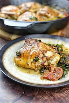 a close up of a plate of food with chicken and spinach on the side