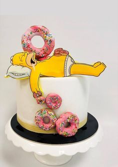 a decorated cake with donuts and doughnuts sitting on it's side