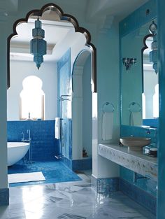 a bathroom with blue and white walls and flooring, including a bathtub in the middle