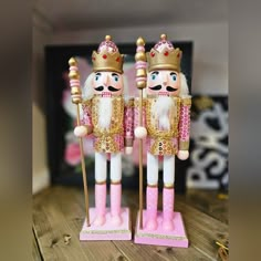 two pink and gold nutcrackers are standing next to each other on a table