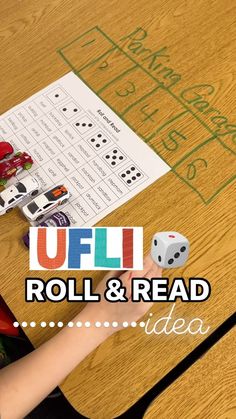 a child is playing with roll and read dice game on the table in front of them