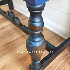 a blue table with metal legs sitting on top of a hard wood floor