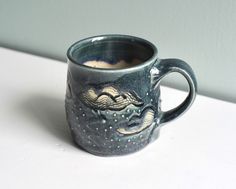 a ceramic mug with a dragon design on it