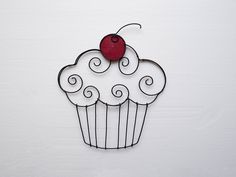 a metal cupcake with a cherry on top and swirls in the shape of a heart