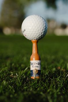 a golf ball on top of a tee in the grass