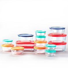 there are many glass containers stacked on top of each other, all with lids in different colors